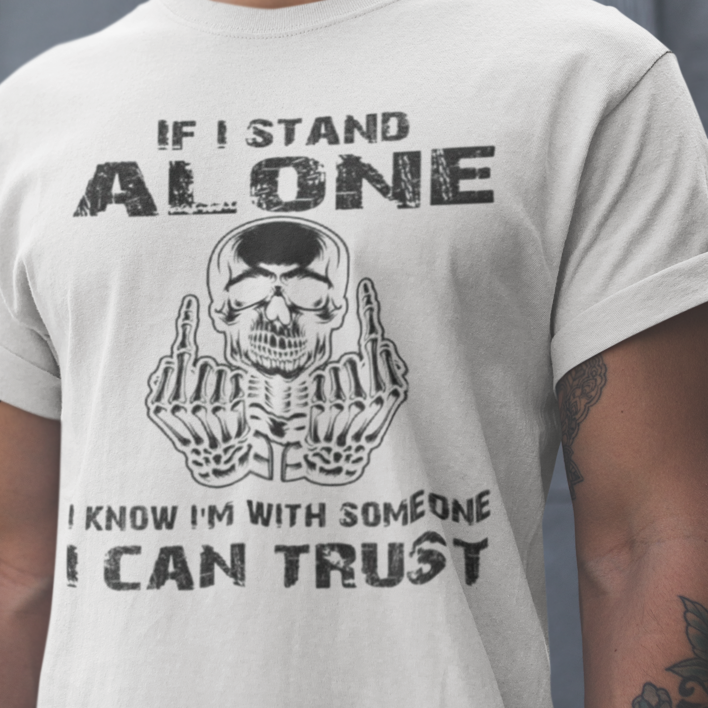 Person wearing a t-shirt with a skull graphic and text against a gray background
