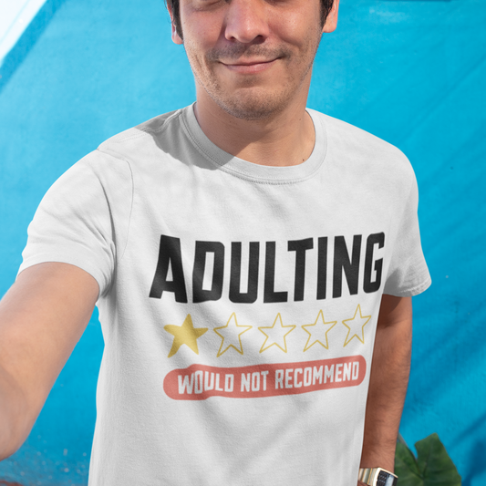Man wearing a t-shirt with 'ADULTING Would Not Recommend' text against a blue wall.