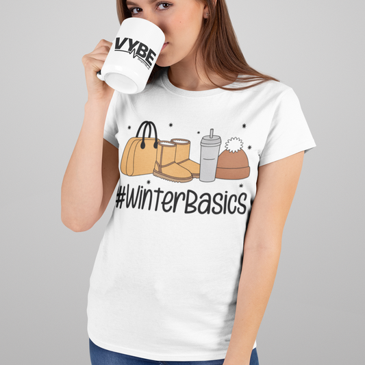 Woman wearing a white t-shirt with '#WinterBasics' design, holding a mug.