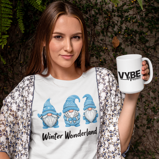 Woman holding a mug with 'VYBE' branding, wearing a 'Winter Wonderland' t-shirt with gnome design.