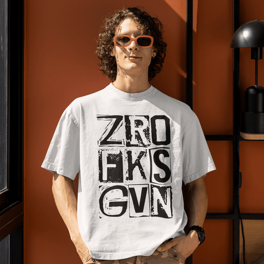 Person wearing a white t-shirt with text and camouflage pants standing against an orange wall.