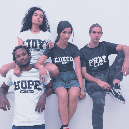 Four people wearing t-shirts with motivational phrases on a white background