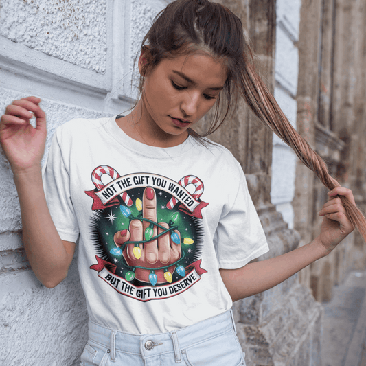 Person wearing a white t-shirt with a graphic design, standing against a textured wall.