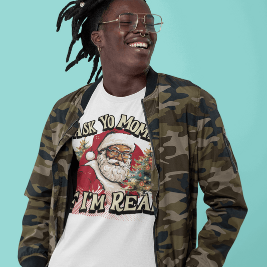 Person wearing a camouflage jacket and a white t-shirt with a graphic design on a teal background
