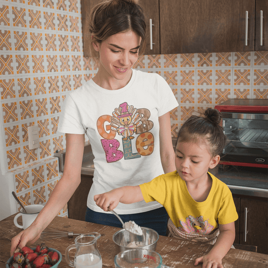 Woman and child in a kitchen preparing food together.