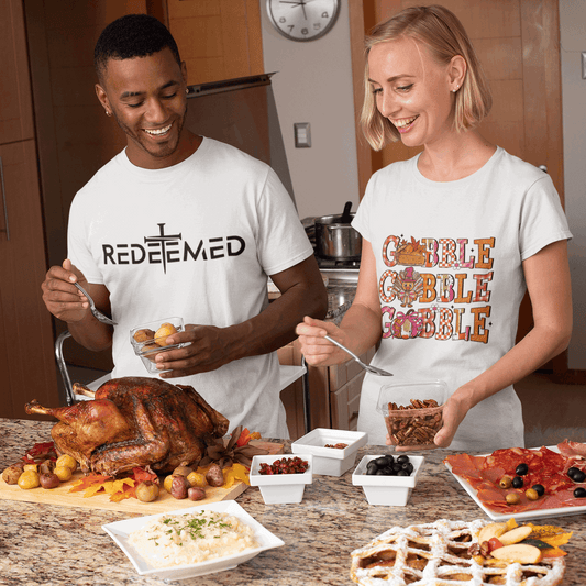 Two people in a kitchen preparing a meal with a large roasted turkey on a table.