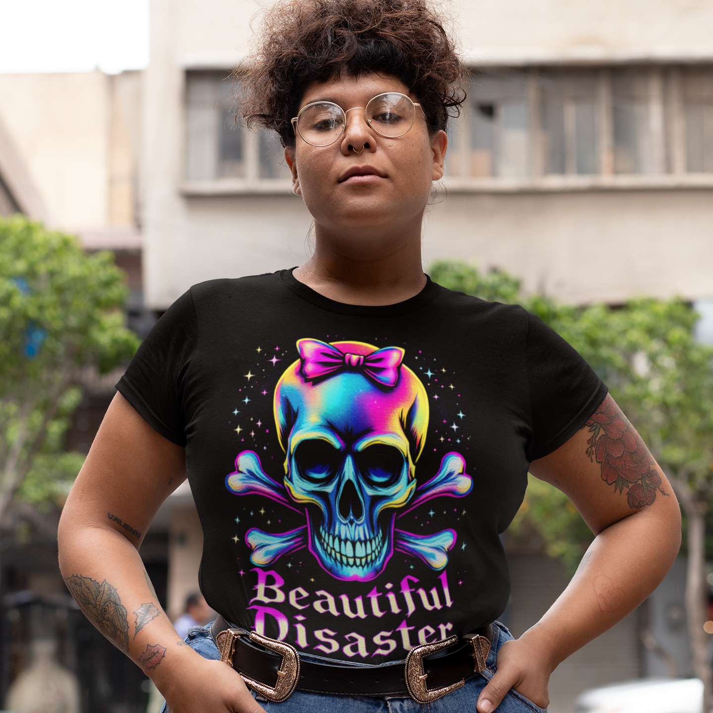 Person wearing a black t-shirt with a colorful skull design and text, standing outdoors.