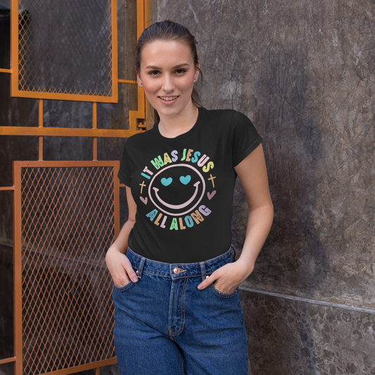 Woman wearing a black t-shirt with colorful text and design, standing against a textured wall.
