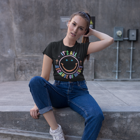 Woman sitting on concrete steps wearing a graphic t-shirt and jeans.