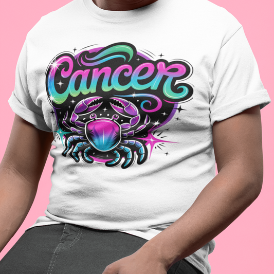 Person wearing a white t-shirt with a colorful 'Cancer' design on a pink background