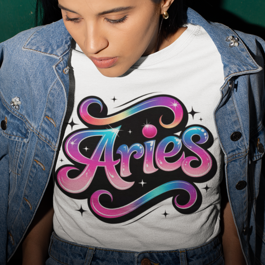 Person wearing a white t-shirt with 'Aries' design, standing against a green wall.