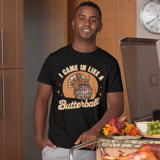 Man wearing a black t-shirt with a graphic design, standing in a kitchen with a Thanksgiving meal.