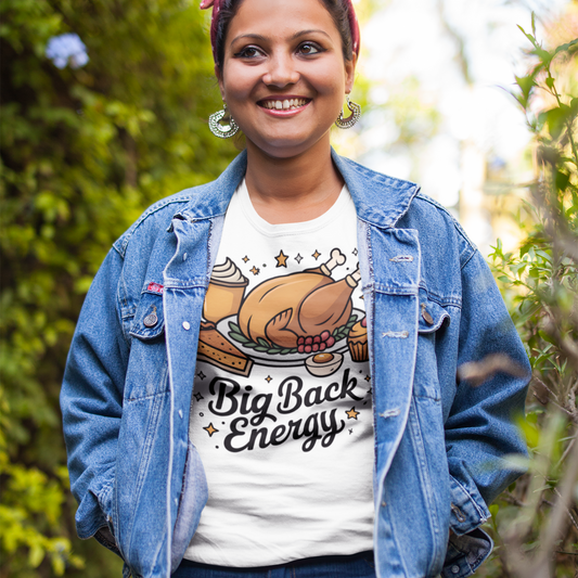Person wearing a denim jacket and t-shirt with a graphic design outdoors
