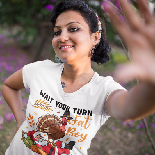 Woman wearing a white t-shirt with a graphic design, standing outdoors with blurred flowers in the background.