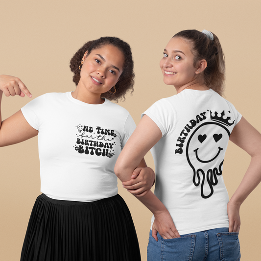 Two women wearing white t-shirts with black text and graphics on a beige background
