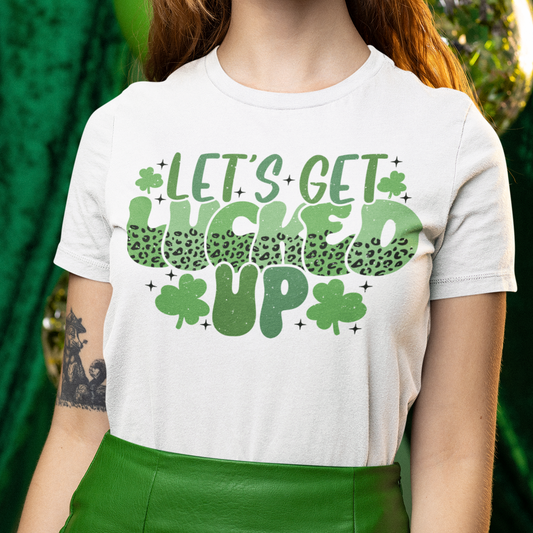 Person wearing a white t-shirt with green text and shamrock design, standing against a green background.