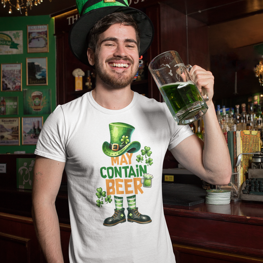 Man in a bar wearing a t-shirt with a St. Patrick's Day design and holding a mug of green beer.