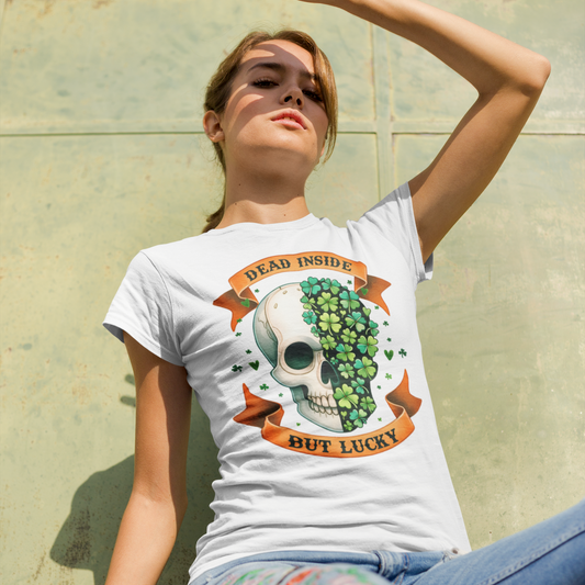 Woman wearing a white t-shirt with a skull and cactus design, sitting against a stone wall.