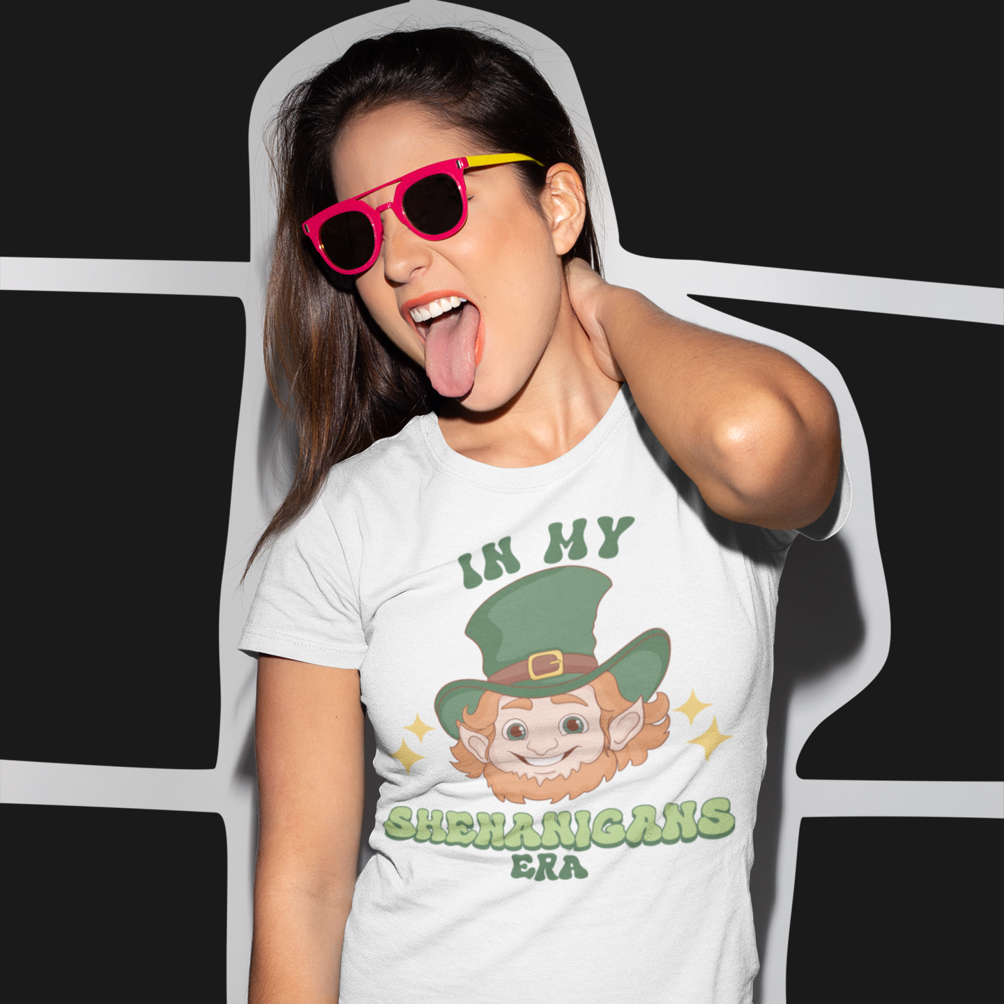 Person wearing a white t-shirt with a graphic design and text, standing against a black and white striped background.