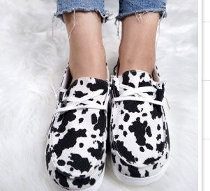 Black and white cow print shoes on a white background